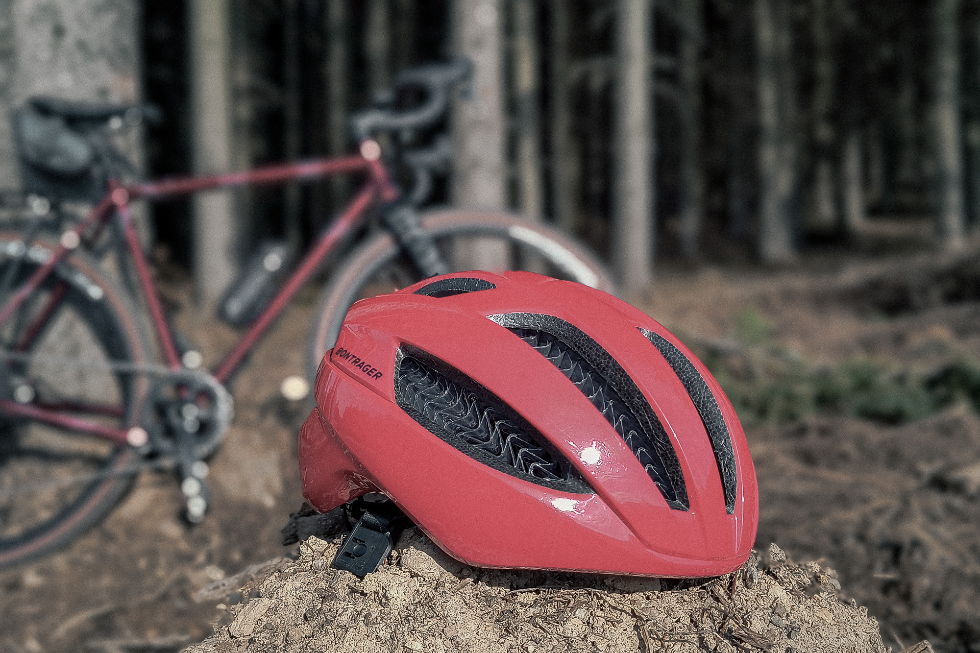 Kask rowerowy leżący w lesie na tle gravela