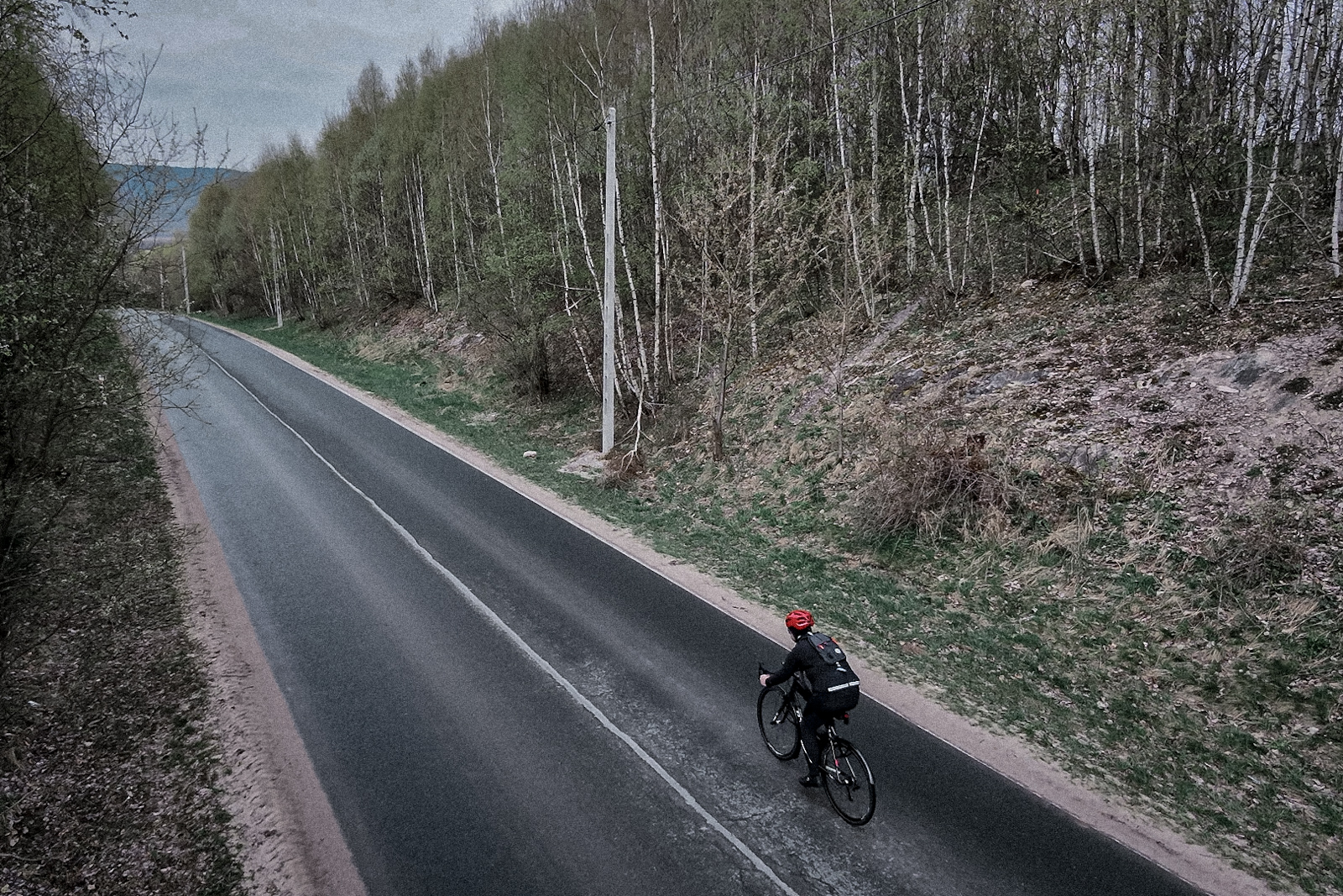 Rowerzysta na rowerze szosowym przygotowujący się do zjazdu